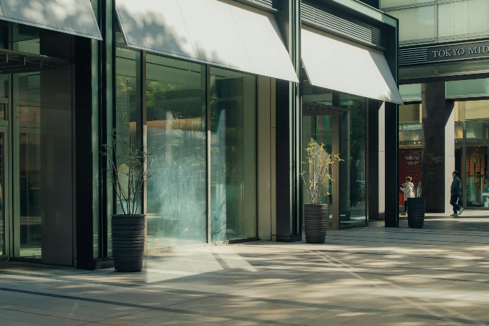 Modern building entrance with glass doors and awnings.